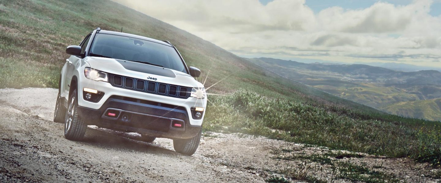 The 2020 Jeep Compass parked on a gravel track on a mountain.