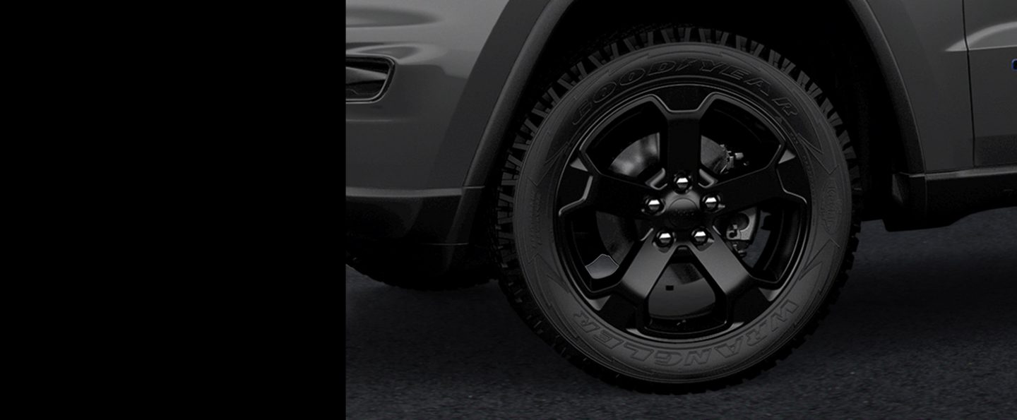 Close-up of one of the gloss black aluminum wheels on the  2020 Jeep Grand Cherokee Upland.