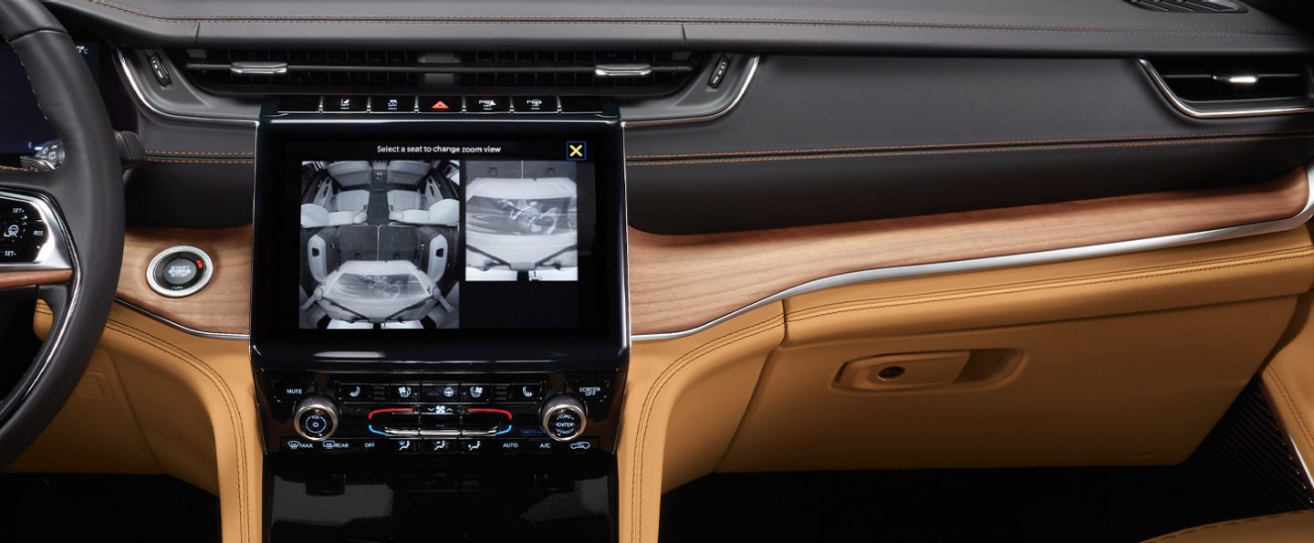 A close-up of the touchscreen in the 2021 Jeep Grand Cherokee L Summit Reserve displaying, on the left, a view of the entire vehicle interior and on the right, a zoomed-in view of the cargo area.